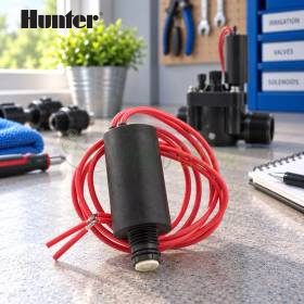 Solenoid 24V me kabllo të kuqe për valvula ujitjeje, trup i zi cilindrik mbi tavolinë pune