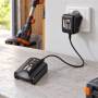 Worx WA3760 20V battery charger plugged into wall outlet on a workbench